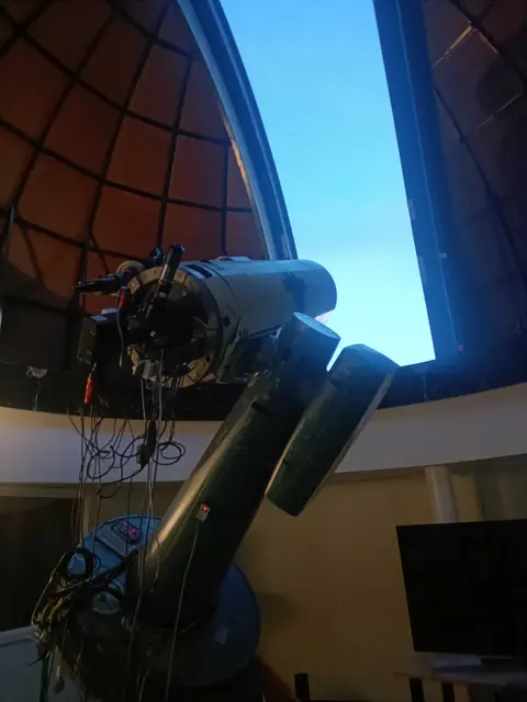 Telescope beneath an observatory dome opening